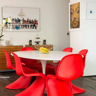 Idées déco pour une salle à manger ouverte sur le salon éclectique de taille moyenne avec un mur blanc, un sol en bois brun et aucune cheminée.