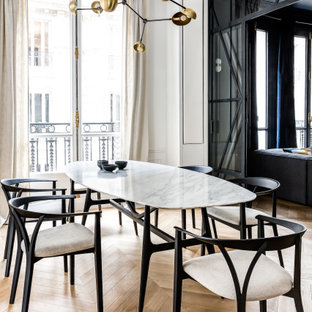 Réalisation d'une salle à manger design avec un mur blanc, un sol en bois brun et un sol marron.
