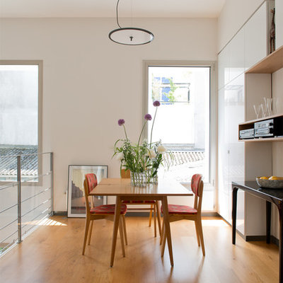 Inspiration for a mid-sized contemporary medium tone wood floor great room remodel in Paris with white walls