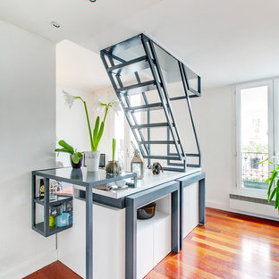 Cette image montre une salle à manger ouverte sur le salon design de taille moyenne avec un mur blanc et un sol en bois brun.