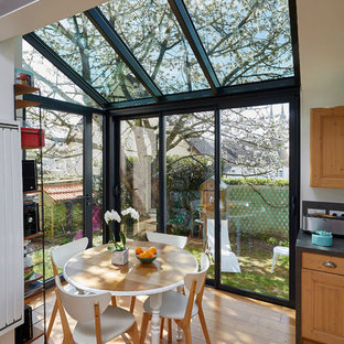 Exemple d'une salle à manger ouverte sur la cuisine tendance de taille moyenne avec aucune cheminée, un mur blanc et un sol en bois brun.
