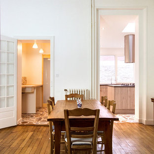 Exemple d'une salle à manger chic de taille moyenne avec un mur blanc et un sol en bois brun.