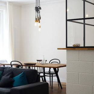 Idée de décoration pour une salle à manger ouverte sur le salon urbaine de taille moyenne avec un mur blanc, un sol en bois brun et aucune cheminée.