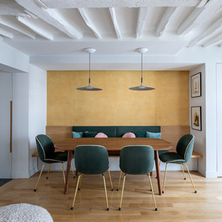 Idée de décoration pour une petit salle à manger ouverte sur le salon design avec un mur jaune, un sol en bois clair, aucune cheminée et un sol beige.
