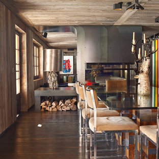 Cette image montre une grand salle à manger ouverte sur le salon design avec un mur marron et un sol en bois brun.