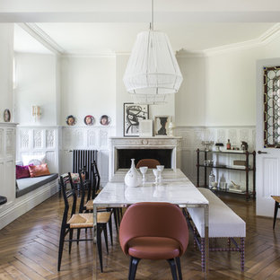 Foto di un'ampia sala da pranzo eclettica chiusa con pareti bianche, pavimento in legno massello medio, camino classico e cornice del camino in pietra