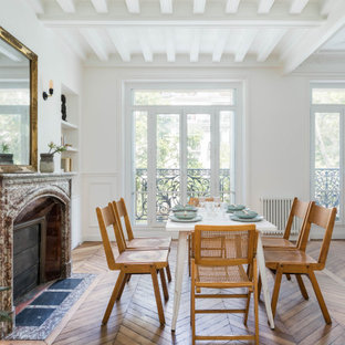 Inspiration pour une salle à manger ouverte sur le salon design avec un mur blanc, un sol en bois brun, une cheminée ribbon et un manteau de cheminée en pierre.