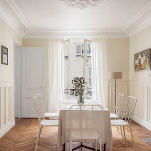 Réalisation d'une salle à manger tradition avec un mur beige, un sol en bois brun, un sol marron et boiseries.