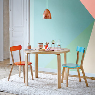 Cette image montre une salle à manger ouverte sur le salon design de taille moyenne avec un mur multicolore, un sol en bois brun et aucune cheminée.