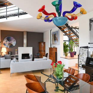Idée de décoration pour une très grand salle à manger design avec un mur blanc, un sol en bois clair, une cheminée standard, un manteau de cheminée en plâtre et un sol beige.