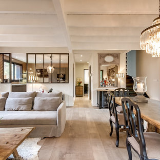 Inspiration pour une grand salle à manger ouverte sur le salon traditionnelle avec un mur beige, un sol en bois clair, un manteau de cheminée en plâtre, un sol beige et une cheminée ribbon.