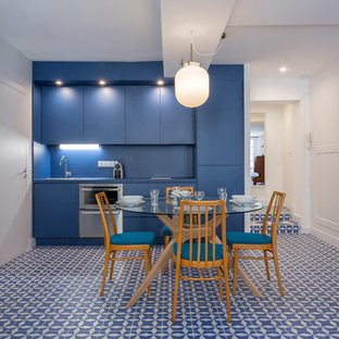 Aménagement d'une salle à manger ouverte sur la cuisine contemporaine avec un mur bleu et un sol bleu.
