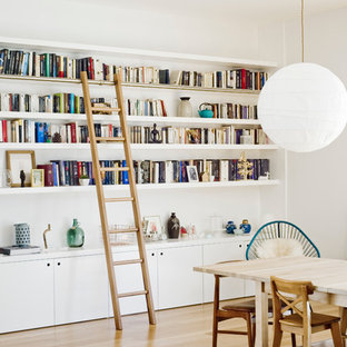 Cette photo montre une salle à manger ouverte sur le salon tendance de taille moyenne avec un mur blanc, un sol en bois clair et aucune cheminée.