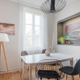 Réalisation d'une salle à manger nordique avec un mur blanc, un sol en bois clair, aucune cheminée et un sol beige.