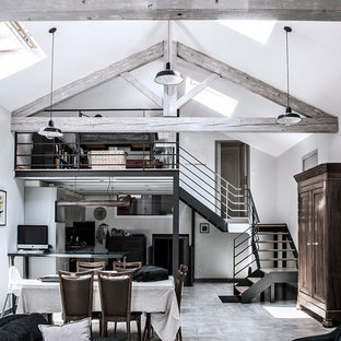 Inspiration pour une grand salle à manger ouverte sur le salon urbaine avec un mur blanc, un sol en carrelage de céramique, un poêle à bois et un manteau de cheminée en métal.