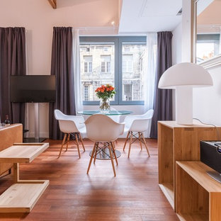 Cette image montre une salle à manger design avec un mur blanc, un sol en bois brun et un sol marron.