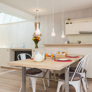 Idée de décoration pour une salle à manger ouverte sur la cuisine design de taille moyenne avec un mur beige et un sol en bois clair.