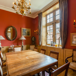 Réalisation d'une salle à manger victorienne avec un mur rouge et un sol en bois brun.