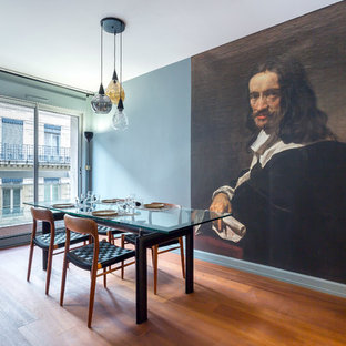 Cette image montre une salle à manger design avec un mur bleu, un sol en bois brun et un sol marron.