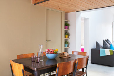 Idée de décoration pour une salle à manger ouverte sur le salon design de taille moyenne avec un mur beige et sol en béton ciré.