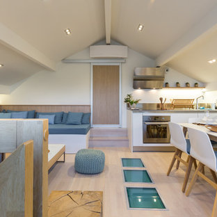 Exemple d'une salle à manger tendance de taille moyenne avec un mur blanc, un sol en bois clair et aucune cheminée.