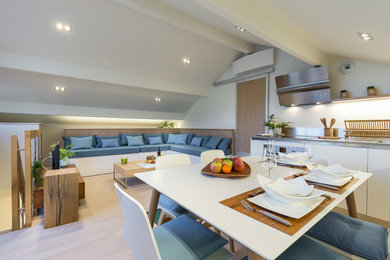 Foto di una sala da pranzo aperta verso il soggiorno minimalista di medie dimensioni con pareti bianche e parquet chiaro