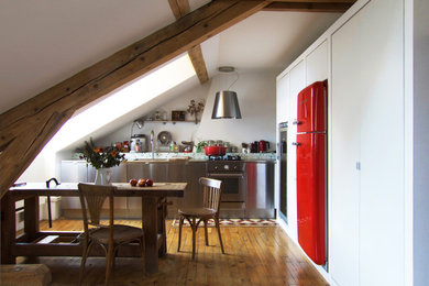 Cette image montre une petite salle à manger ouverte sur le salon urbaine avec un mur blanc, un sol en bois brun et aucune cheminée.