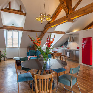 Cette photo montre une salle à manger ouverte sur le salon éclectique avec un mur blanc, un sol en bois brun, un sol marron, un plafond en poutres apparentes et un plafond voûté.