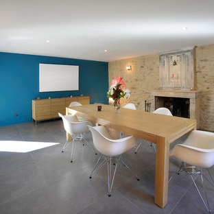 Inspiration pour une salle à manger ouverte sur le salon design de taille moyenne avec un mur bleu, une cheminée standard et un sol en carrelage de céramique.