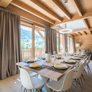 Aménagement d'une salle à manger ouverte sur le salon montagne avec un sol en bois clair, aucune cheminée et un sol beige.