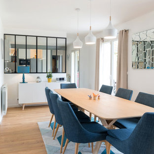 Réalisation d'une grand salle à manger ouverte sur le salon design avec un mur blanc, aucune cheminée, un sol en bois clair et un sol beige.