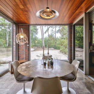 Exemple d'une salle à manger rétro fermée avec aucune cheminée et un sol marron.