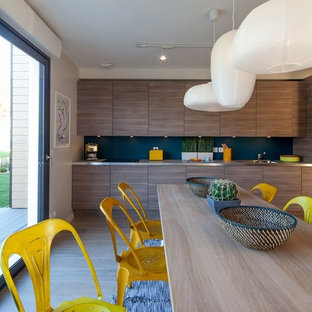 Inspiration pour une salle à manger ouverte sur la cuisine design avec un mur gris et un sol en bois foncé.