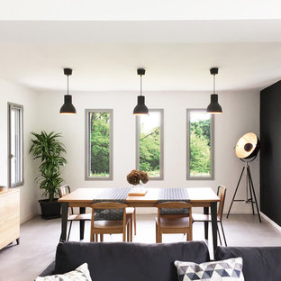 Aménagement d'une salle à manger ouverte sur le salon industrielle avec un mur blanc, aucune cheminée et un sol gris.