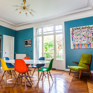Aménagement d'une grand salle à manger contemporaine fermée avec un mur bleu et un sol en bois brun.