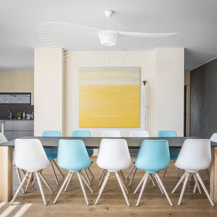 Exemple d'une salle à manger ouverte sur la cuisine tendance avec un mur multicolore et un sol en bois clair.