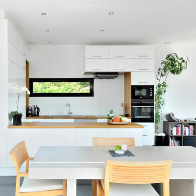 Inspiration for a contemporary concrete floor kitchen/dining room combo remodel in Lyon with white walls