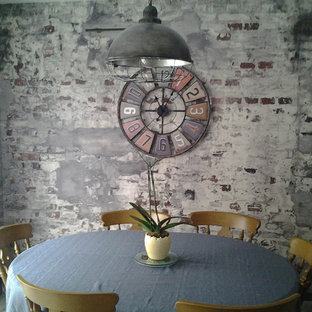 Esempio di una grande sala da pranzo aperta verso la cucina industriale con pareti con effetto metallico, pavimento in laminato, stufa a legna, cornice del camino in metallo e pavimento marrone
