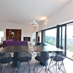 Aménagement d'une grand salle à manger ouverte sur le salon contemporaine avec un mur blanc, béton au sol et aucune cheminée.