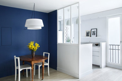 Imagen de comedor contemporáneo de tamaño medio abierto sin chimenea con paredes azules y suelo de madera clara