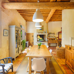 Réalisation d'une salle à manger ouverte sur le salon méditerranéenne de taille moyenne avec un mur beige, une cheminée standard et un manteau de cheminée en plâtre.