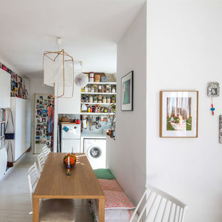 Cette photo montre une salle à manger ouverte sur le salon tendance de taille moyenne avec un mur blanc, un sol en bois peint et aucune cheminée.