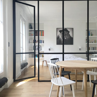Immagine di una sala da pranzo scandinava di medie dimensioni con pareti bianche, parquet chiaro e nessun camino