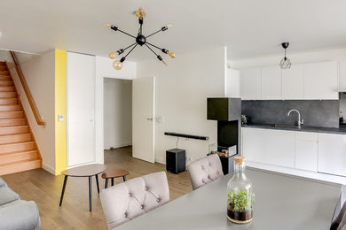 Cette image montre une salle à manger minimaliste de taille moyenne avec un mur jaune, un sol en bois brun et aucune cheminée.