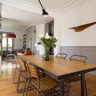 Inspiration pour une salle à manger ouverte sur le salon traditionnelle de taille moyenne avec un mur blanc et un sol en bois brun.