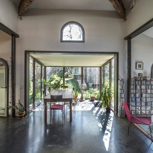 Idées déco pour une grand salle à manger ouverte sur le salon campagne avec béton au sol, aucune cheminée et un mur beige.