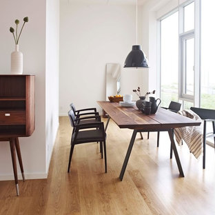 Cette photo montre une salle à manger scandinave fermée et de taille moyenne avec un mur blanc et un sol en bois brun.