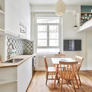 Esempio di una piccola sala da pranzo aperta verso il soggiorno scandinava con pareti bianche, pavimento in legno massello medio e pavimento marrone