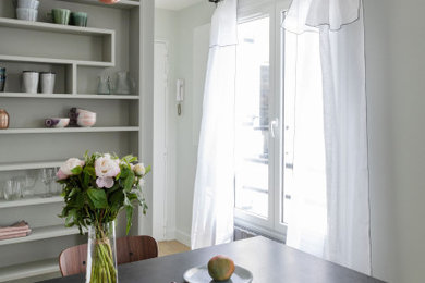 Idée de décoration pour une petite salle à manger ouverte sur le salon minimaliste avec un mur gris et parquet clair.