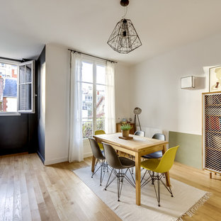 Aménagement d'une salle à manger ouverte sur le salon contemporaine avec un mur blanc, un sol en bois clair et aucune cheminée.